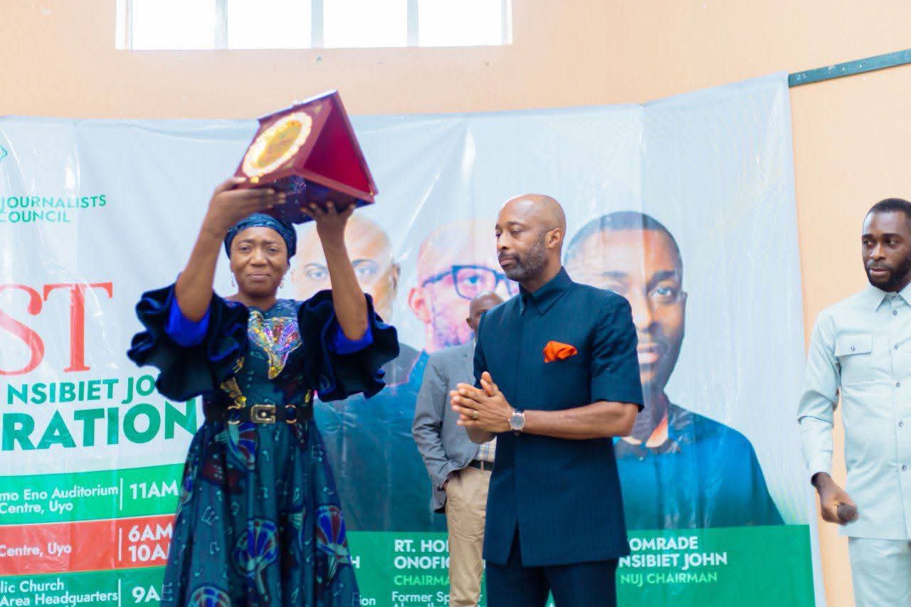 NUJ leadership summit charts new course for professionalism, union growth in Akwa Ibom 17 • An awardee displaying her award of merit, while Barr Onofiok Luke & Comrade Nsibiet John applaud